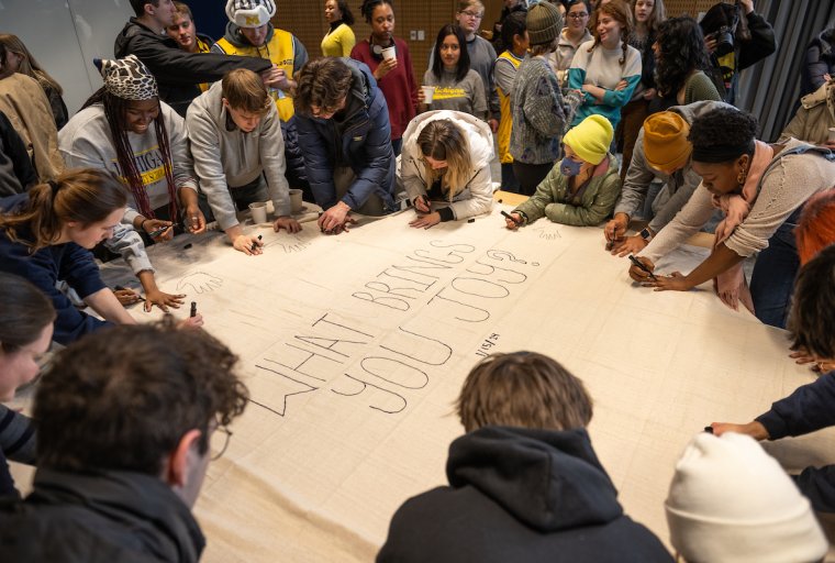 Group of students working on a collaborative art project as part of the Circle of Unity program. The text in the center reads "What Brings You Joy"?