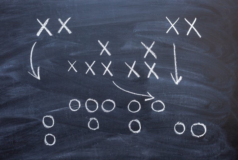 A chalkboard football play outline with Xs and Os.