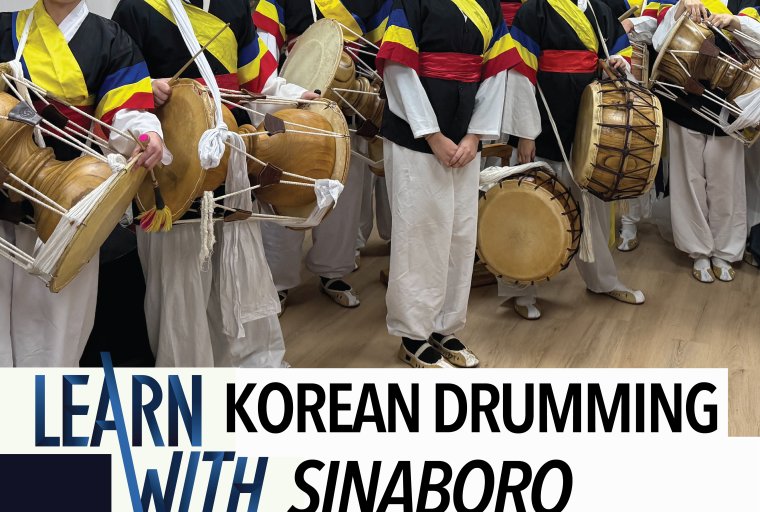 Twelve students pose with drums in traditional Korean costume