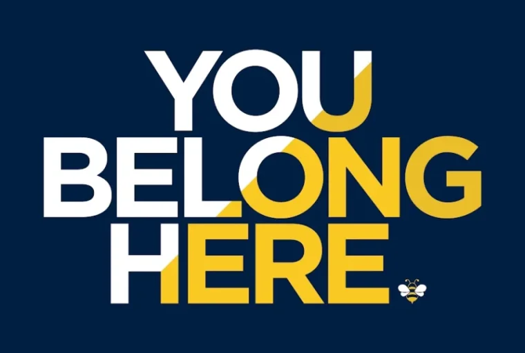 You Belong Here Logo with blue background and words stacked with small bee at end.