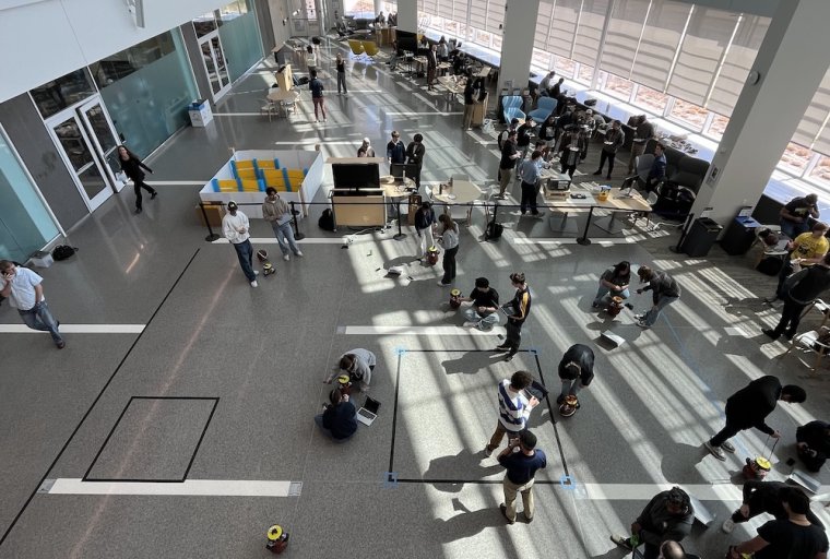 Students gather for a demo day in the Robotics Building atrium with robotics projects on display