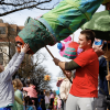 A UM student engaging with audience members through their giant puppet during the FestiFools parade!