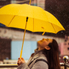 Person standing under an umbrella smiling