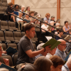 Risers with choral singers and their sheet music.