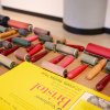 Printmaking equipment - brayers and rollers - is arranged next to a yellow Bristol pad of paper.