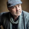 Colum McCann (headshot) in cap, scarf and sport coat.