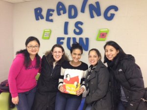 photo of Michigan students in front of "Reading is Fun" sign