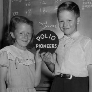 Image of two children who received the polio vaccine holding a sign