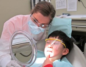 2013 GKAS dental student Jessica Gillis with a youngster who takes a closer look