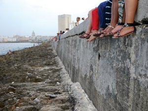 Student sitting on Malecon wall, Havana, Cuba