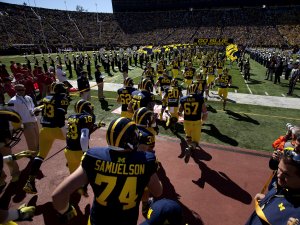 Michigan football players running onto the field at the Big House