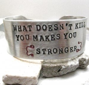 Bracelet that says "What does not kill you, makes you stronger."
