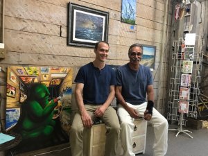 Kenneth Gourlay and Martin Vargas take a break hanging artwork at Ledge Craft Lane.