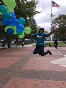 person jumping holding balloons in the diag