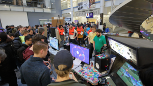 A large crowd plays new student-made video games at the EECS 494 + EMU Showcase