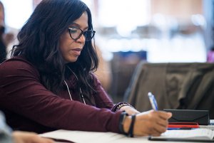 Black woman writing and looking down at her paper Black woman writing and looking down at her paper