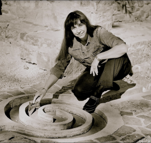 Dr. Bruchac brushing an object off in the dirt