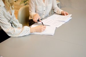 Two persons filling out a sheet of paper