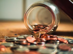 Jar turned on its side, coins spilling out Jar turned on its side, coins spilling out
