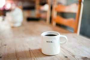 Photo of white mug with BEGIN. on wood table by Danielle MacInnes on Unsplash