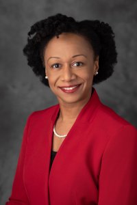 Doctor Joneigh Khaldun wearing a red jacket and smiling at the viewer Doctor Joneigh Khaldun wearing a red jacket and smiling at the viewer