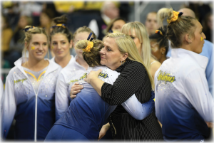 Coach Bev Plocki hugging U-M Gymnastics team member