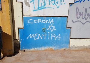 Graffiti on Calle del Doctor Luis Calandre in Cartagena (Spain), in which the pandemic is referred to as a "corona-mentira" ("corona-lie") and connects with Anti-Semitic and Anti-Chinese rhetoric through the inclusion of a Mogen Covid and a Chinese character.  Taken 14 February 2021
