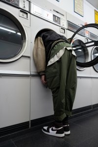 Person leaning full body into washing machine