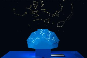A paper domed art sculpture cast in blue light, projecting constellations from pinprick holes.