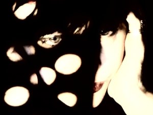 An image of Lydia Lunch, cast in shadow.