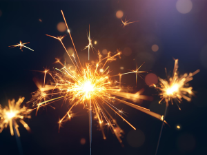 Three lit sparklers with a black background