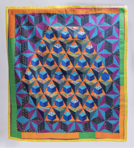 Geo metric quilt that is purple, blue, orange and green.