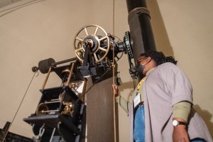 Image of a woman looking into a telescope.