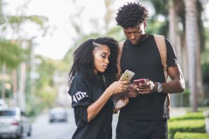 Black girl and guy looking at cell phone