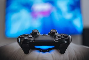 Video game controller in front of blue TV screen