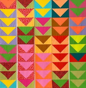 Image of colorful quilt with triangles in a repeating pattern
