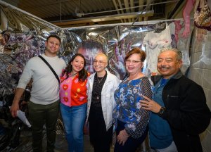 A student and family members gathered in front of work at the 2022 Senior Exhibition