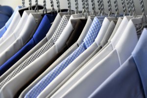 a row of dress shirts on hangers