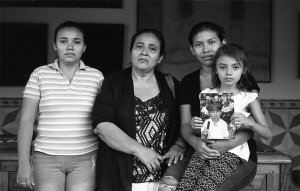 The family of murdered Danny Ezequiel López Morales hold his photo in this black and white image.