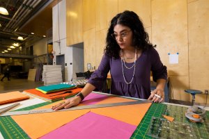 Michelle Inez Hinojosa (MFA ‘23), works on pieces of a quilt for her thesis exhibition.