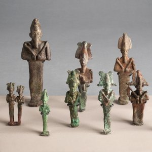 Eight metal Egyptian Orisis figurines stand against a neutral background.