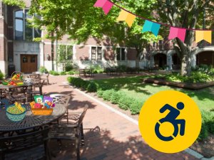 Outside courtyard with brightly colored flags, food and an icon of a wheelchair in a yellow circle.
