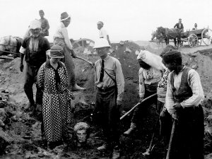 Archival photo of Enoch Peterson and Turkish laborers uncovering a statue of the head of Augustus at an excavation in Antioch, Turkey.