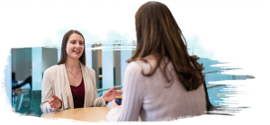 Two people talking while sitting down