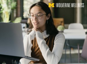 woman in glasses looking at her laptop computer screen
