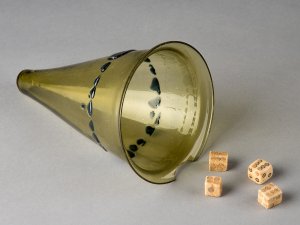 Conical green glass dice cup with four bone dice.