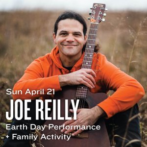 Sun April 21 Joe Reilly Earth Day Performance + Family Activity displays in white text across a photo of artist Joe Reilly sitting in a field with a guitar.