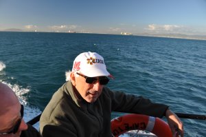 Photo of Hugh MacIsaac on a boat wearing sunglasses and a white baseball cap