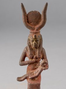 Bronze figurine of the Egyptian goddess Isis breastfeeding her son, Horus. She has the horns of a cow on her head with a solar disk between them.