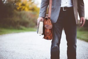 Man with leather bag and book